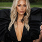 Black and White Monique Gown featuring dramatic puff sleeves and plunging neckline, showcased outdoors against natural greenery