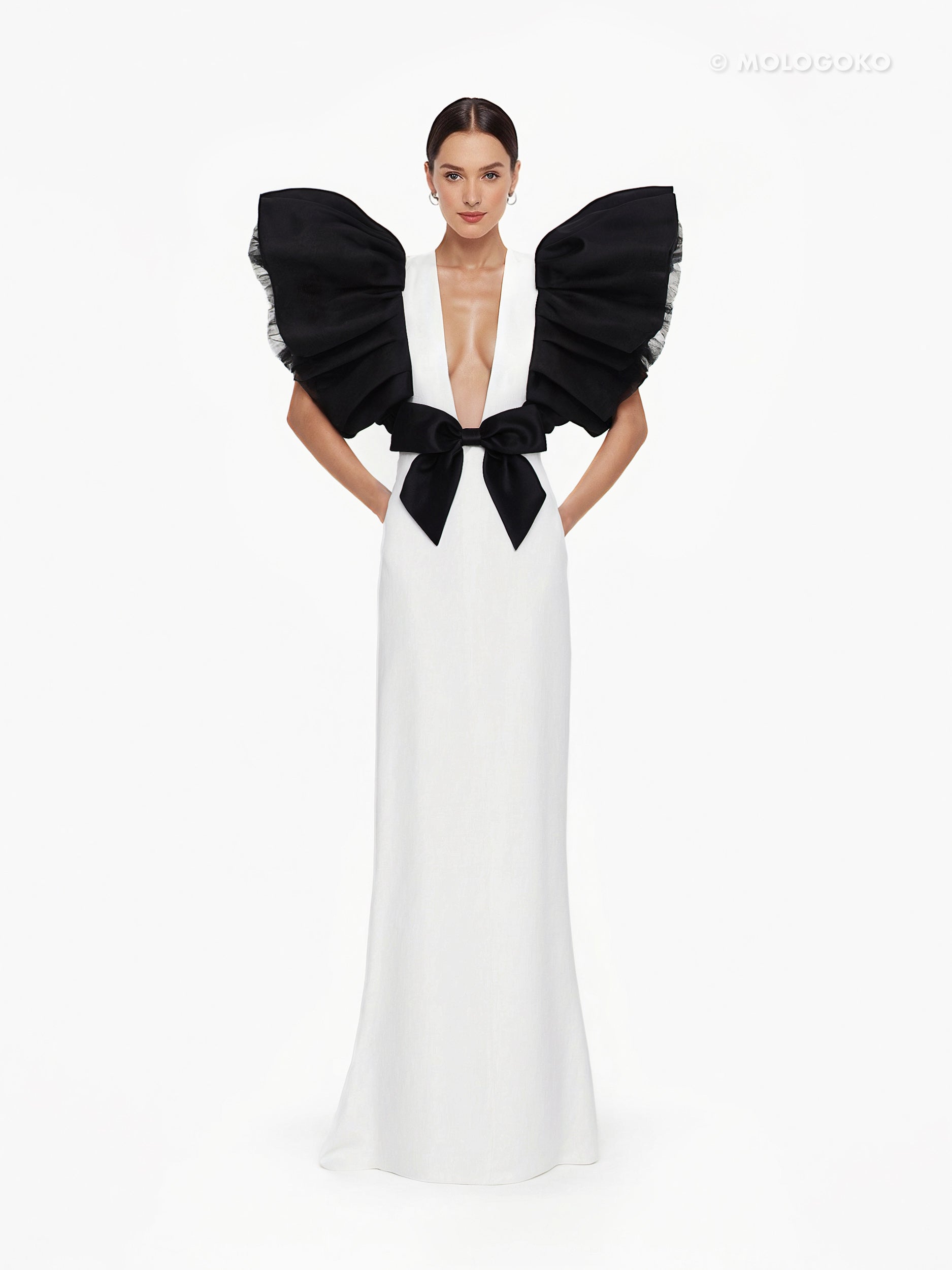 Black and White Monique Gown with dramatic ruffled sleeves, plunging neckline, and black bow detail on white floor-length dress