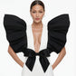 Black and White Monique Gown featuring dramatic puff sleeves, plunging neckline, and black bow accent on white dress