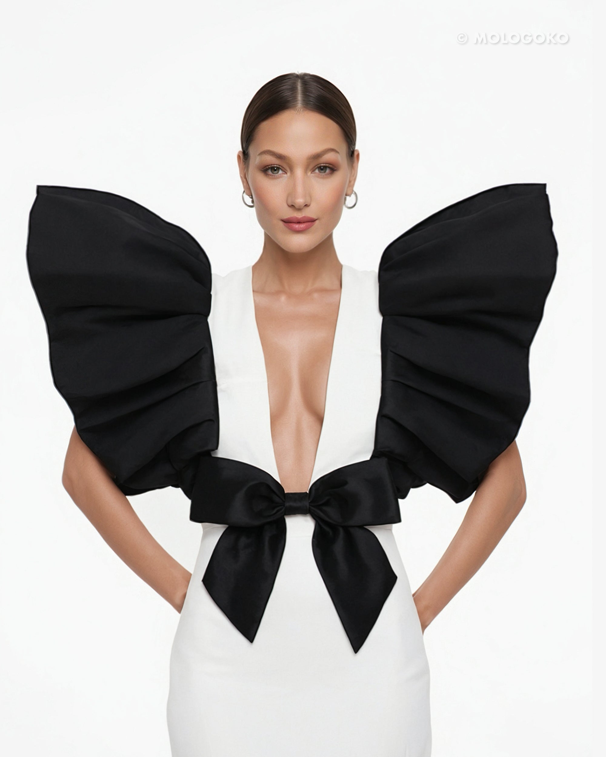Black and White Monique Gown featuring dramatic puff sleeves, plunging neckline, and black bow accent on white dress
